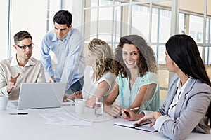 Casual businesswoman smiling at camera during meeting