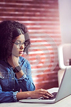 Casual businesswoman using laptop and smartwatch