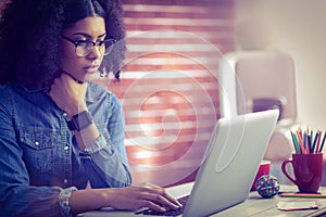 Casual businesswoman using laptop and smartwatch