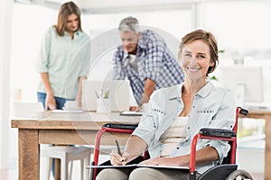 Casual businesswoman in wheelchair with notepad