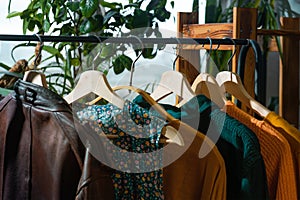 Casual clothes hanging on floor hanger at home.