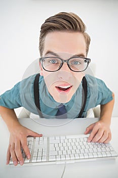 Casual confused businessman typing at his desk