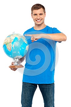 Casual cool guy pointing at rotating globe