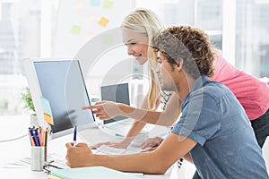 Casual couple using computer in office