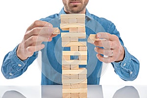 Casual dressed man playing a game of jenga