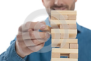 Casual dressed man removing a brick from the tower