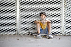Casual dressed young smiling teen skater outdoors portrait