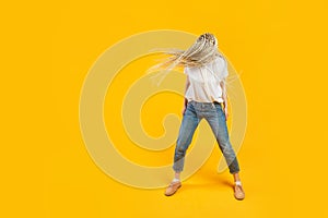 Casual dressed young woman with kanekalons or braids having fun. Headbanging