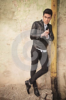 Casual fashion man leaning on a old pipe