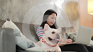 Casual freelance Asian cute woman working from home with her dog.