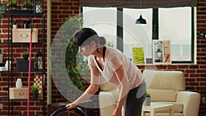 Casual girl using vacuum cleaner to tidy up apartment