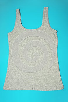 Gray sleeveless female casual tank top on blue background. Sport, fitness aparrel. Basic look photo