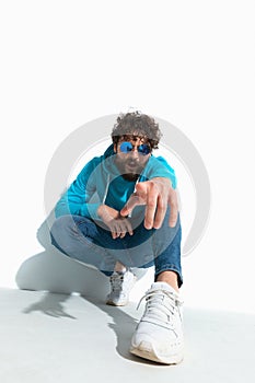 Casual guy with cool style is pointing at the camera