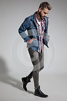Casual guy walking with hands in pocket and looking down