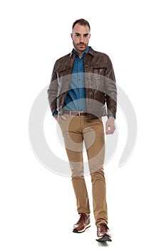 Casual guy wearing denim shirt, chino pants, leather jacket and sneakers