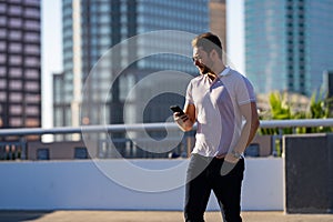 Casual handsome man chatting on phone in urban city. Well-dressed man talking on phone outdoor. Businessman using phone