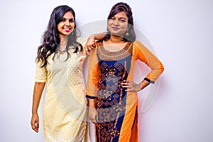 casual indian clothes ,two Indian woman in kurta posing over white wall