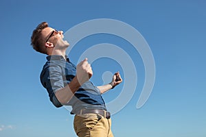 Casual man cheering outdoors