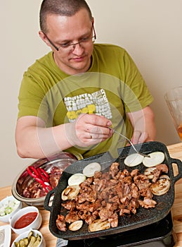 Casual man cooking meat