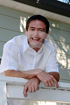 Casual man leaning over rail