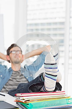 Casual man with legs on desk in office