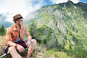 Casual man looks back at mountain