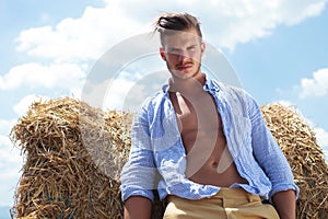 Casual man outdoor looks down with unbuttoned shirt