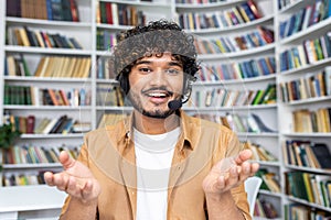 Casual man with outstretched hands in a library, concept of choice and decision making