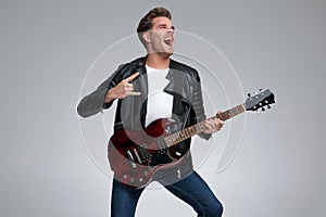 Casual man playing his guitar passionate
