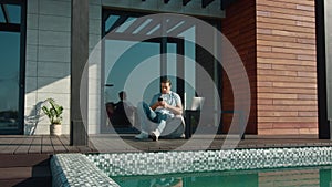 Casual man resting with mobile phone. Handsome man using mobile at luxury house