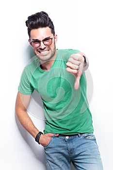 Casual man showing the thumb down gesture