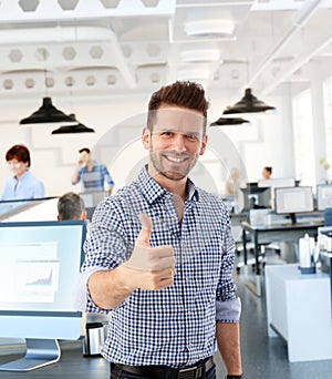 Casual man showing thumb-up in office