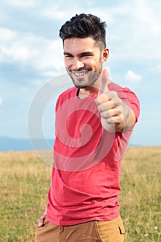 Casual man shows thumbs up