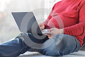 Casual man sitting and working with laptop on wooden floor