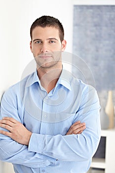 Casual man standing arms crossed smiling