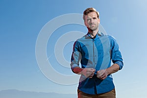 Casual man standing with hands close looking away pensive