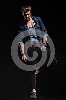 Casual man standing on one leg in a fashion pose