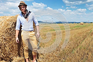 Casual man stands next to haystack