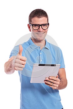 Casual man with tablet shows thumb up