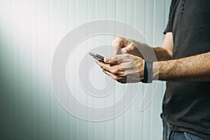 Casual man using smart phone to send text message photo