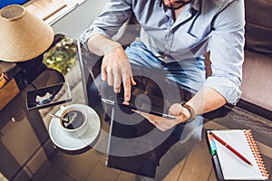 Casual Man Using Tablet Computer Sitting in Cafe Surfing Internet