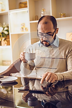 Casual Man Using Tablet Computer Sitting in Cafe Surfing Internet