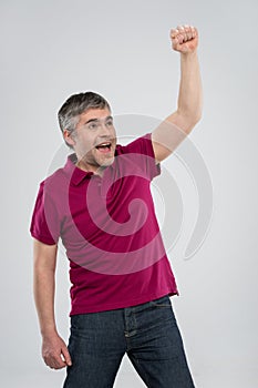 Casual man winning and celebrating over white background.