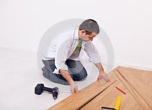 Casual man or worker installing flooring