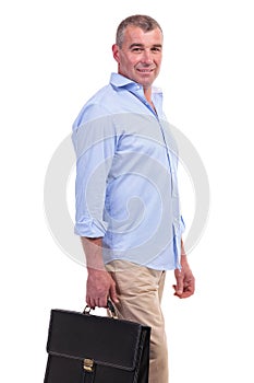 Casual middle aged man holding a suitcase