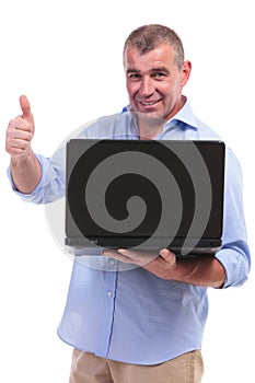 Casual middle aged man thumb up with laptop
