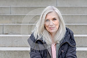 Casual middle-aged woman sitting on outdoor steps