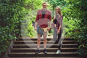 Casual moder young skateboarders couple posing on footway.