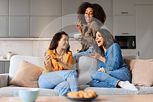 Casual moment girlfriends laughing and drinking coffee