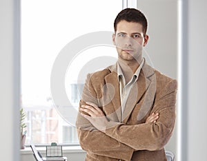 Casual office worker standing arms crossed